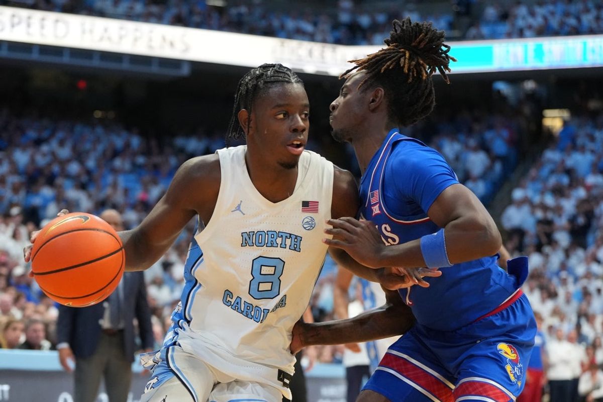 Nov 7, 2025; Chapel Hill, North Carolina, USA;  North Carolina Tar Heels forward Caleb Wilson (8) with the the ball as Kansas Jayhawks guard Jamari McDowell (11) defends in the second half at Dean E. Smith Center. Mandatory Credit: Bob Donnan-Imagn Images