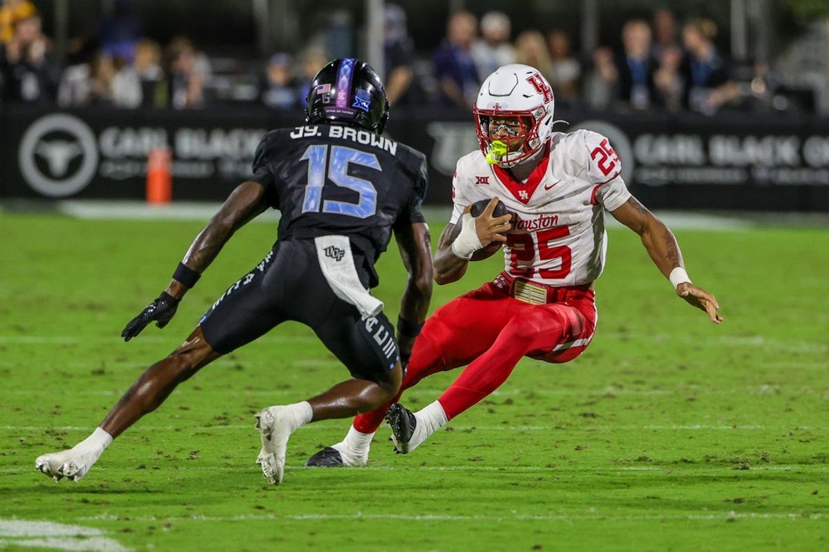 Nov 7, 2025; Orlando, Florida, USA; Houston Cougars running back DJ Butler (25) runs the ball against UCF Knights cornerback Jyaire Brown (15) during the first quarter at Acrisure Bounce House. Mandatory Credit: Mike Watters-Imagn Images
