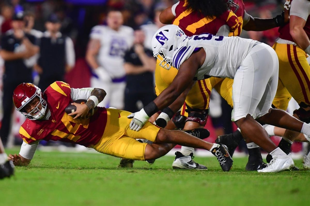 Nov 7, 2025; Los Angeles, California, USA; Southern California Trojans quarterback Jayden Maiava (14) falls as Northwestern Wildcats defensive lineman Najee Story (95) moves in during the first half at the Los Angeles Memorial Coliseum. Mandatory Credit: Gary A. Vasquez-Imagn Images