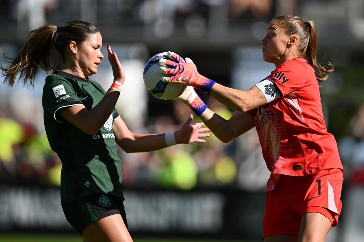 Nov 8, 2025; Washington, District of Columbia, USA;  Washington Spirit goalkeeper Aubrey Kingsbury (1) gets control of the ball as Racing Louisville FC forward Emma Sears (13) closes in during the first half at Audi Field. Mandatory Credit: Jamie Sabau-Imagn Images