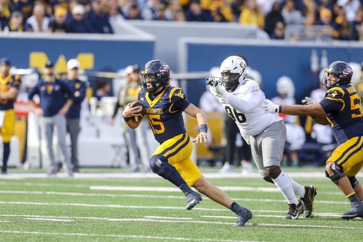 Nov 8, 2025; Morgantown, West Virginia, USA; West Virginia Mountaineers quarterback Scotty Fox Jr. (15) runs out of the pocket during the second quarter against the Colorado Buffaloes at Milan Puskar Stadium. Mandatory Credit: Ben Queen-Imagn Images