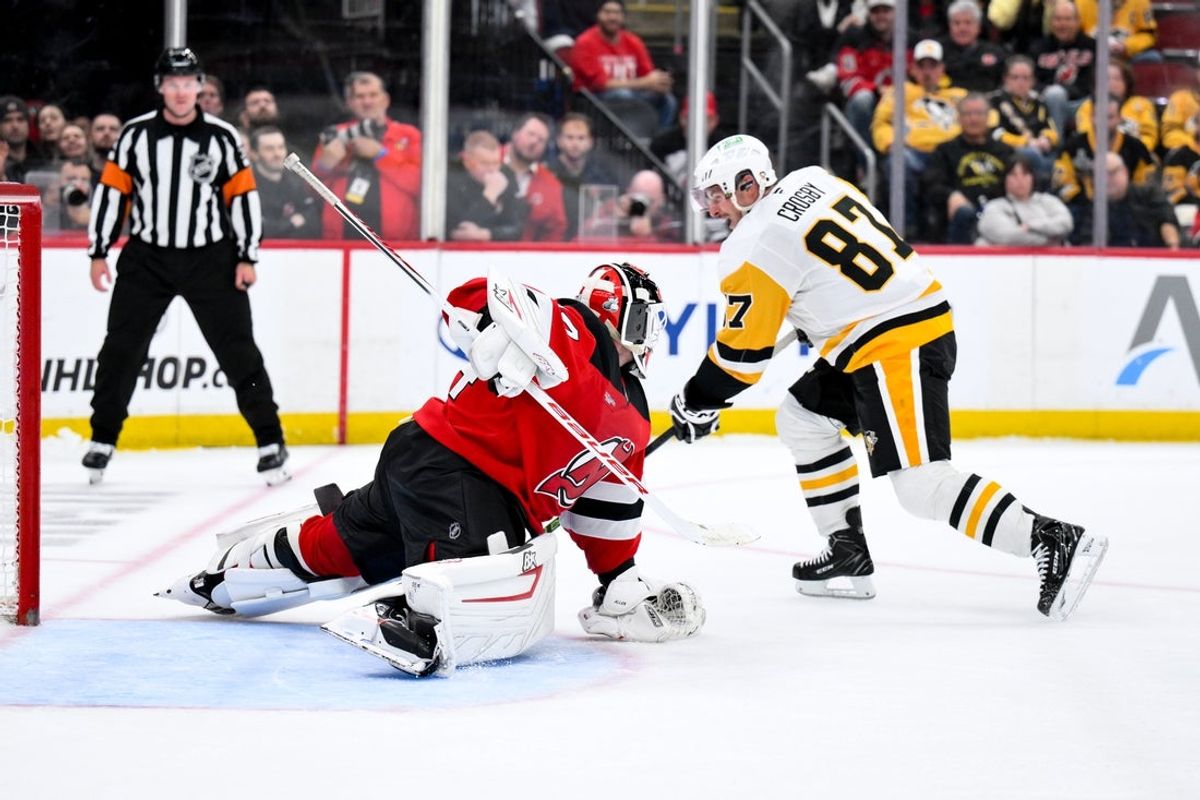 Nov 8, 2025; Newark, New Jersey, USA; New Jersey Devils goaltender Jake Allen (34) makes a save against Pittsburgh Penguins center Sidney Crosby (87) during the overtime shootout period at Prudential Center. Mandatory Credit: John Jones-Imagn Images