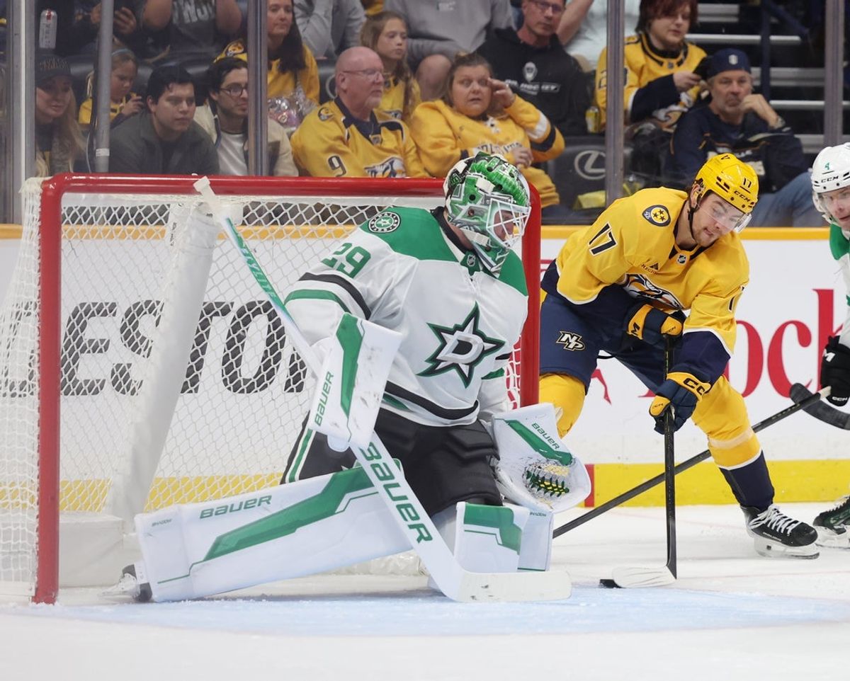 Nov 8, 2025; Nashville, Tennessee, USA; Nashville Predators center Tyson Jost (17) attacks the goal as Dallas Stars goal tender Jake Oettinger (29) guards the goal during the first period at Bridgestone Arena. Mandatory Credit: Alan Poizner-Imagn Images