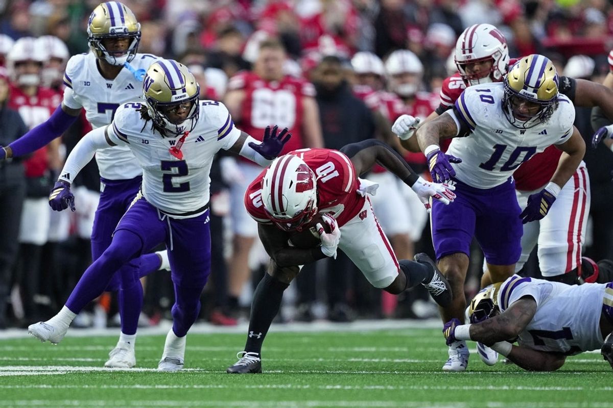 Nov 8, 2025; Madison, Wisconsin, USA;  Wisconsin Badgers running back Gideon Ituka (10) is tackled by Washington Huskies cornerback Ephesians Prysock (7) during the first quarter at Camp Randall Stadium. Mandatory Credit: Jeff Hanisch-Imagn Images