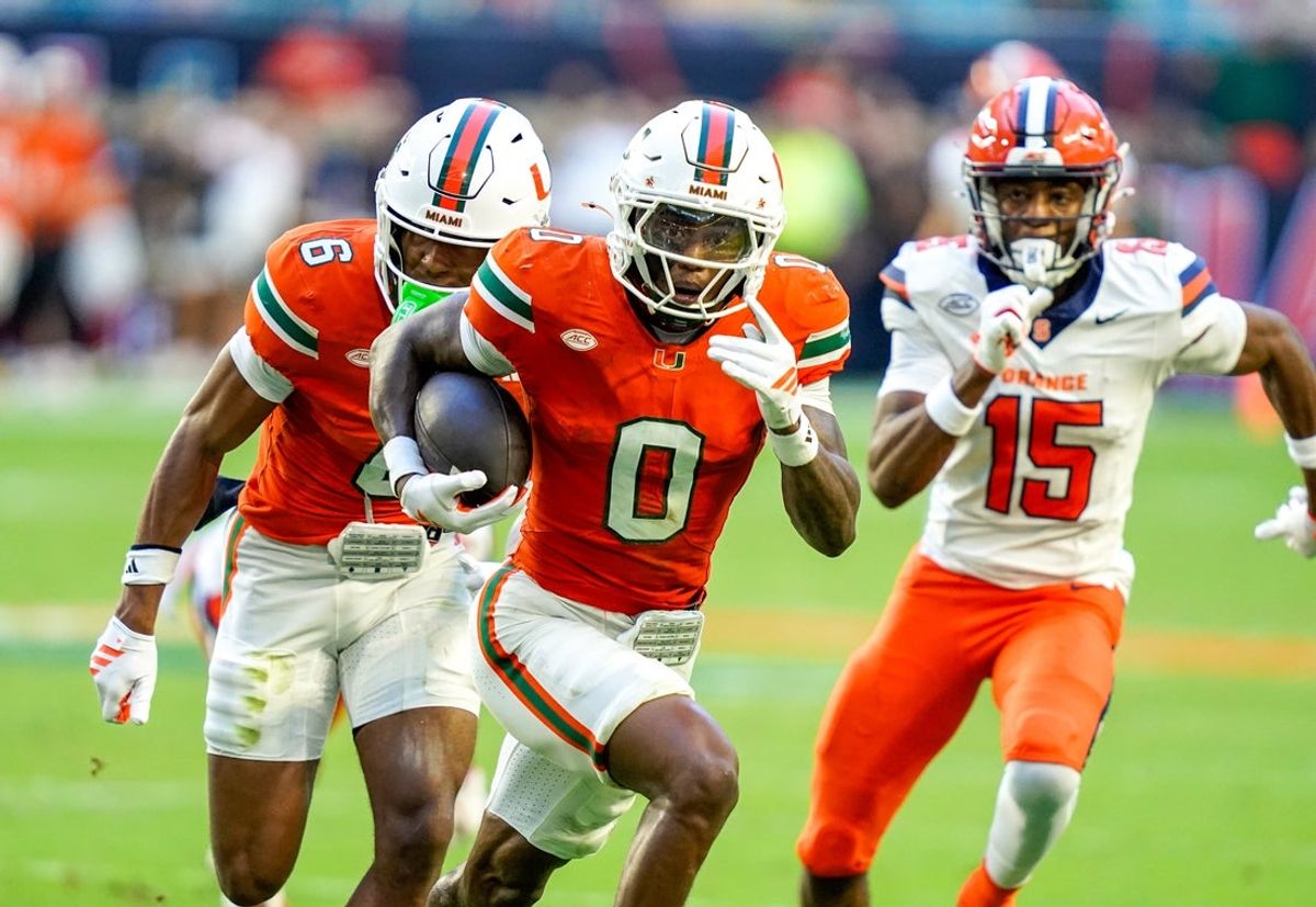 Nov 8, 2025; Miami Gardens, Florida, USA; Miami Hurricanes defensive back Keionte Scott (0) returns an interception for a touchdown in a game against the Syracuse Orange during the second quarter at Hard Rock Stadium. Mandatory Credit: Jeff Romance-Imagn Images