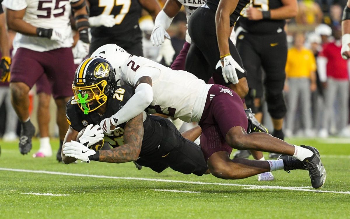 Nov 8, 2025; Columbia, Missouri, USA; Missouri Tigers running back Jamal Roberts (20) dives forward against Texas A&M Aggies cornerback Dezz Ricks (2) during the second half at Faurot Field at Memorial Stadium. Mandatory Credit: Jay Biggerstaff-Imagn Images