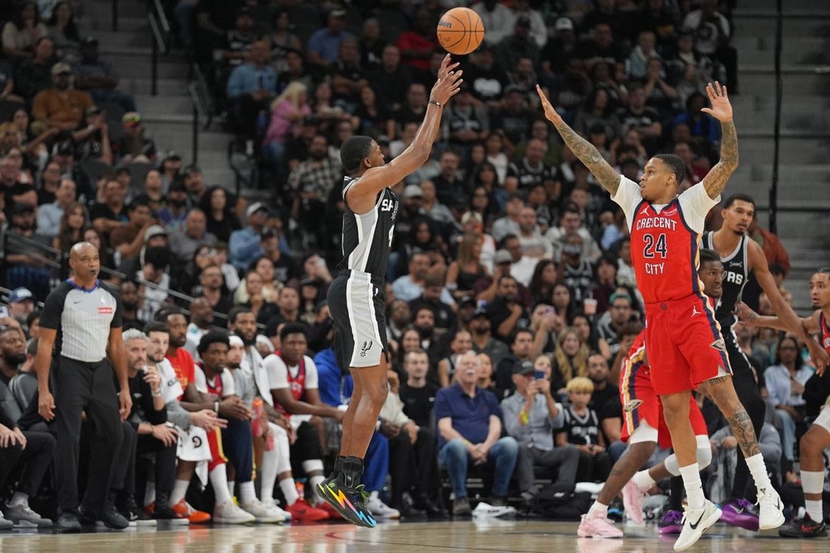 Nov 8, 2025; San Antonio, Texas, USA;  San Antonio Spurs guard De'Aaron Fox (4) shoots over New Orleans Pelicans guard Jordan Hawkins (24) in the first half at Frost Bank Center. Mandatory Credit: Daniel Dunn-Imagn Images