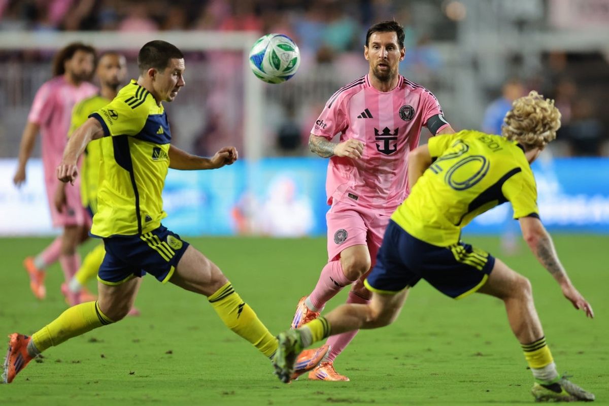 Nov 8, 2025; Fort Lauderdale, Florida, USA; Inter Miami CF forward Lionel Messi (10) passes the ball as Nashville SC midfielder Alex Muyl (19) and midfielder Edvard Tagseth (20) defend during the second half at Chase Stadium. Mandatory Credit: Sam Navarro-Imagn Images