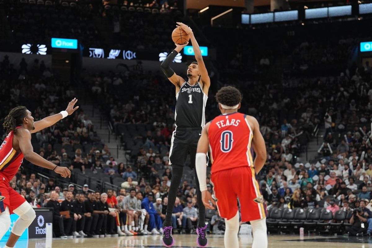 Nov 8, 2025; San Antonio, Texas, USA;  San Antonio Spurs forward Victor Wembanyama (1) shoots in front of New Orleans Pelicans guard Jeremiah Fears (0) in the second half at Frost Bank Center. Mandatory Credit: Daniel Dunn-Imagn Images