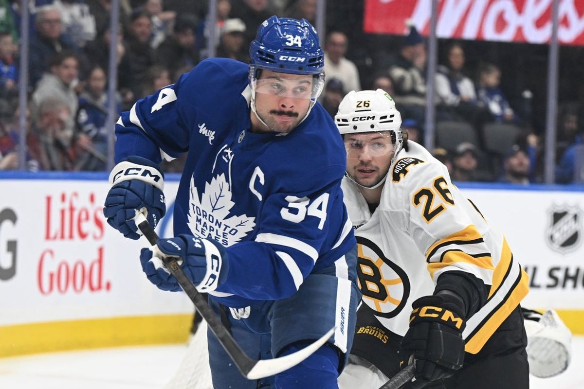Nov 8, 2025; Toronto, Ontario, CAN;  Toronto Maple Leafs forward Auston Matthews (34) pursues the puck ahead of Boston Bruins defenseman Andrew Peeke (26) in the first period at Scotiabank Arena. Mandatory Credit: Dan Hamilton-Imagn Images
