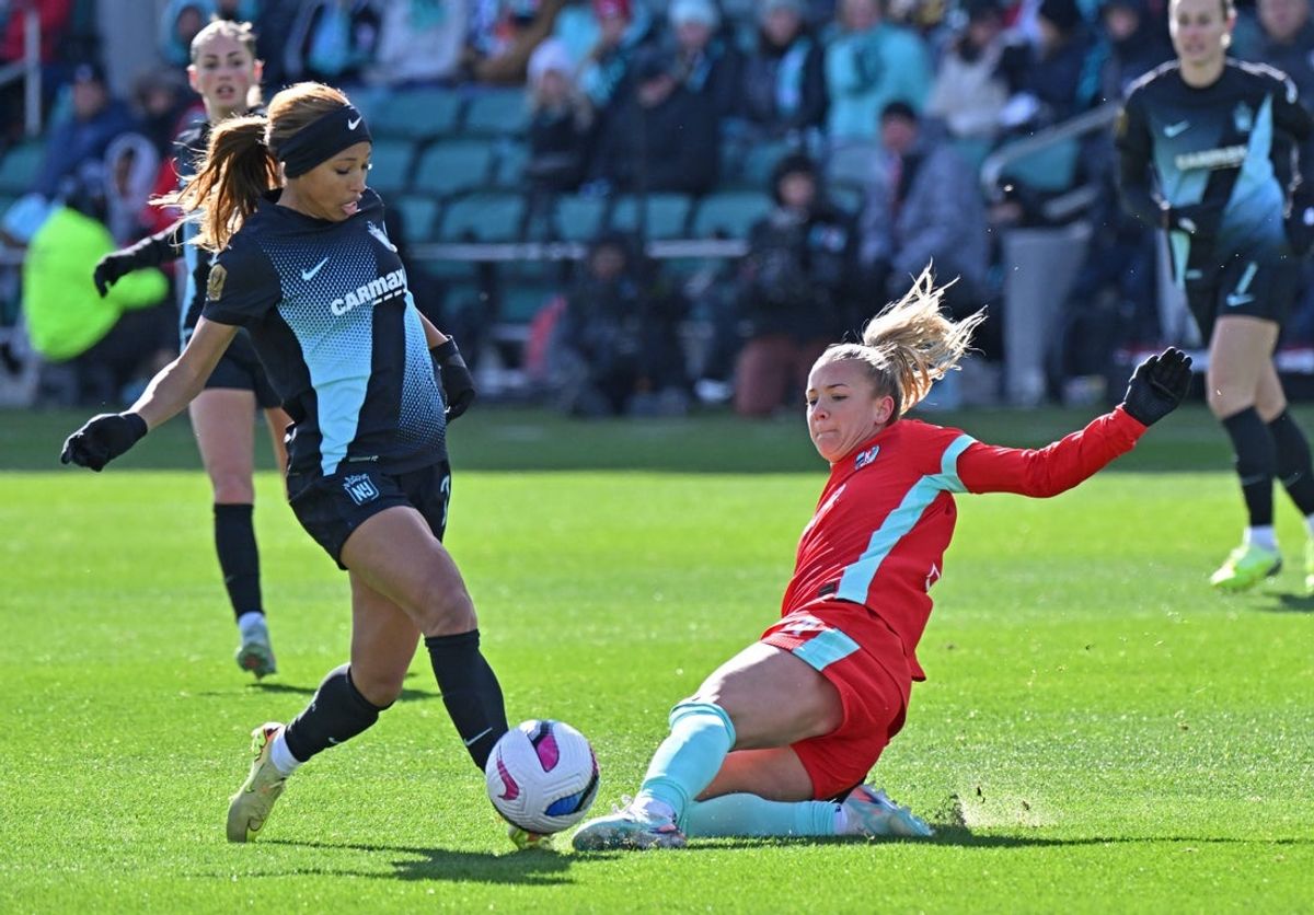 Nov 9, 2025; Kansas City, Missouri, USA;  Kansas City Current midfielder Claire Hutton (14) slides in for the ball against NJ/NY Gotham FC forward Midge Purce (23) in the first half at CPKC Stadium. Mandatory Credit: Peter Aiken-Imagn Images