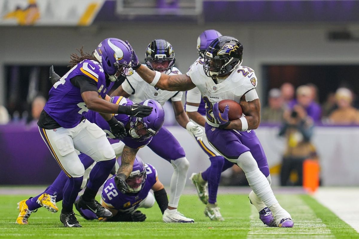 Nov 9, 2025; Minneapolis, Minnesota, USA; Baltimore Ravens running back Derrick Henry (22) runs with the ball against Minnesota Vikings safety Joshua Metellus (44) in the second quarter at U.S. Bank Stadium. Mandatory Credit: Brad Rempel-Imagn Images