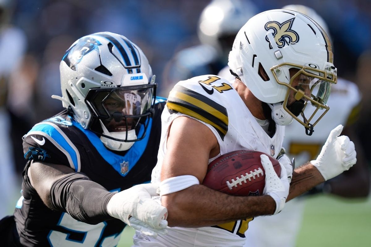 Nov 9, 2025; Charlotte, North Carolina, USA; New Orleans Saints wide receiver Dante Pettis (11) runs after making a catch as Carolina Panthers linebacker Claudin Cherelus (53) tackles during the second quarter at Bank of America Stadium. Mandatory Credit: Jim Dedmon-Imagn Images