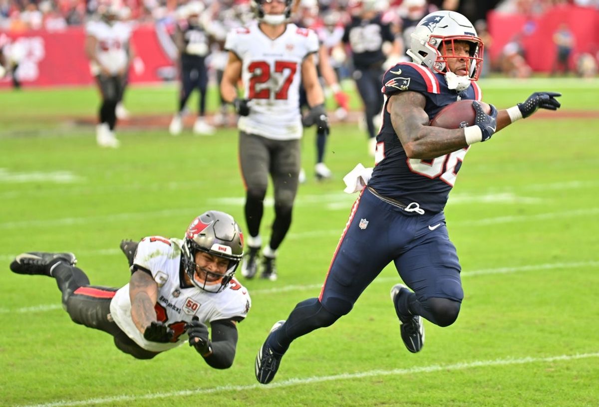 Nov 9, 2025; Tampa, Florida, USA; New England Patriots running back Treveyon Henderson (32) runs for a touchdown past Tampa Bay Buccaneers cornerback Josh Hayes (32) during the third quarter at Raymond James Stadium. Mandatory Credit: Jonathan Dyer-Imagn Images