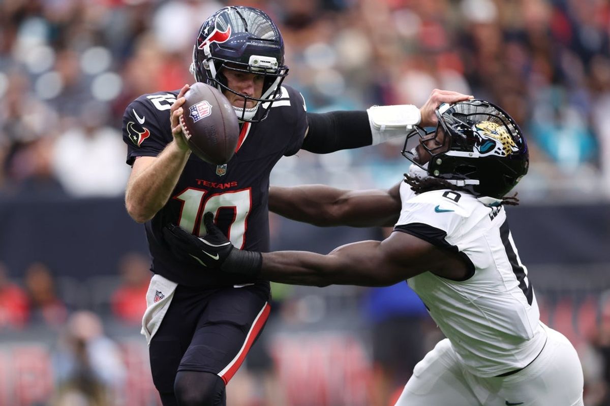 Nov 9, 2025; Houston, Texas, USA; Houston Texans quarterback Davis Mills (10) is pressured by Jacksonville Jaguars linebacker Devin Lloyd (0) during the first half at NRG Stadium. Mandatory Credit: Troy Taormina-Imagn Images