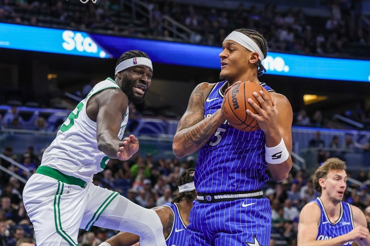 Nov 9, 2025; Orlando, Florida, USA; Orlando Magic forward Paolo Banchero (5) grabs the rebound in front of Boston Celtics center Neemias Queta (88) during the first quarter at Kia Center. Mandatory Credit: Mike Watters-Imagn Images