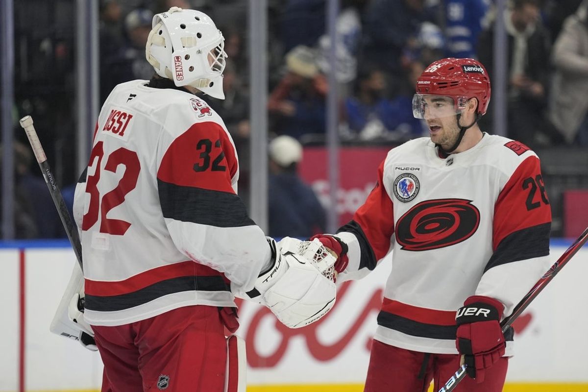 Nov 9, 2025; Toronto, Ontario, CAN; Carolina Hurricanes defenseman Sean Walker (26) congratulates goaltender Brandon Bussi (32) after a win against the Toronto Maple Leafs during the third period at Scotiabank Arena. Mandatory Credit: John E. Sokolowski-Imagn Images