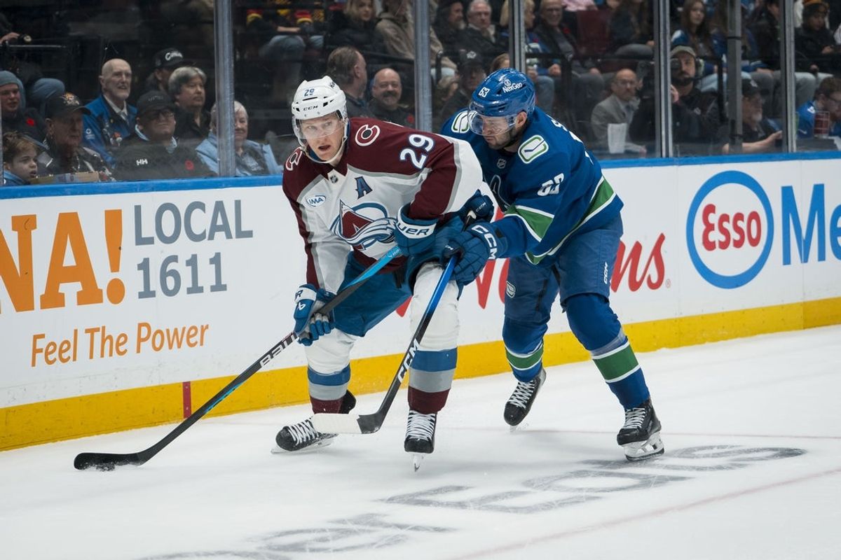 Nov 9, 2025; Vancouver, British Columbia, CAN;Vancouver Canucks forward Max Sasson (63) battles with Colorado Avalanche forward Nathan MacKinnon (29)  in the first period at Rogers Arena. Mandatory Credit: Bob Frid-Imagn Images