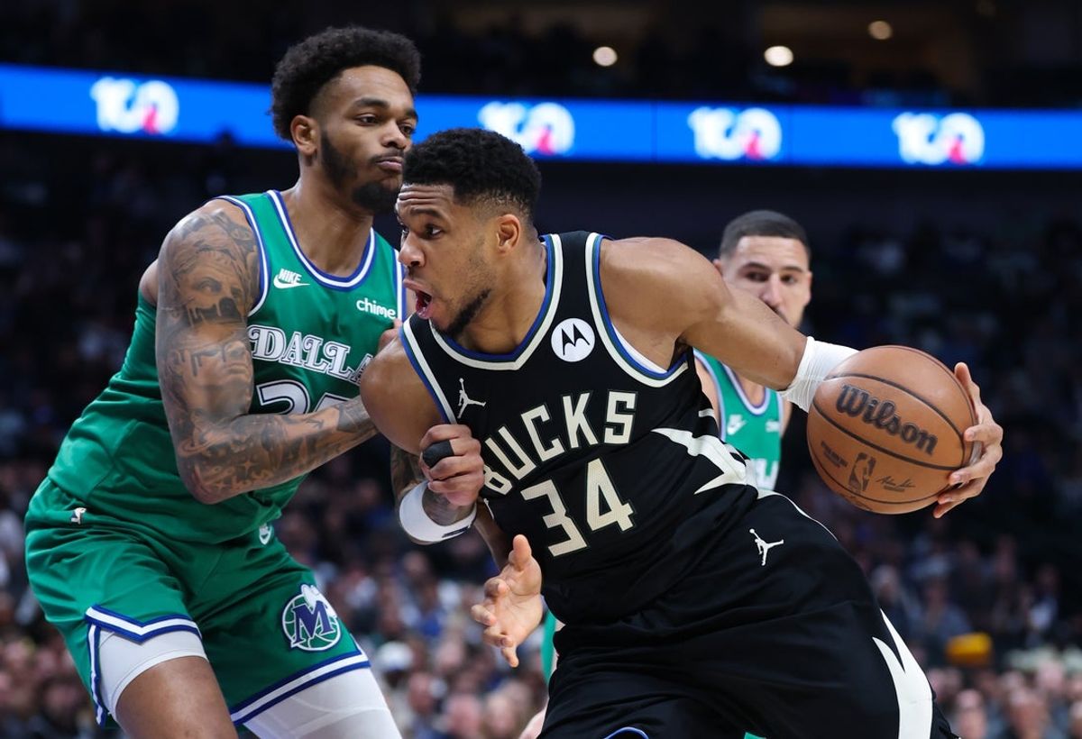 Nov 10, 2025; Dallas, Texas, USA; Milwaukee Bucks forward Giannis Antetokounmpo (34) drives to the basket as Dallas Mavericks forward P.J. Washington (25) defends during the first quarter at American Airlines Center. Mandatory Credit: Kevin Jairaj-Imagn Images