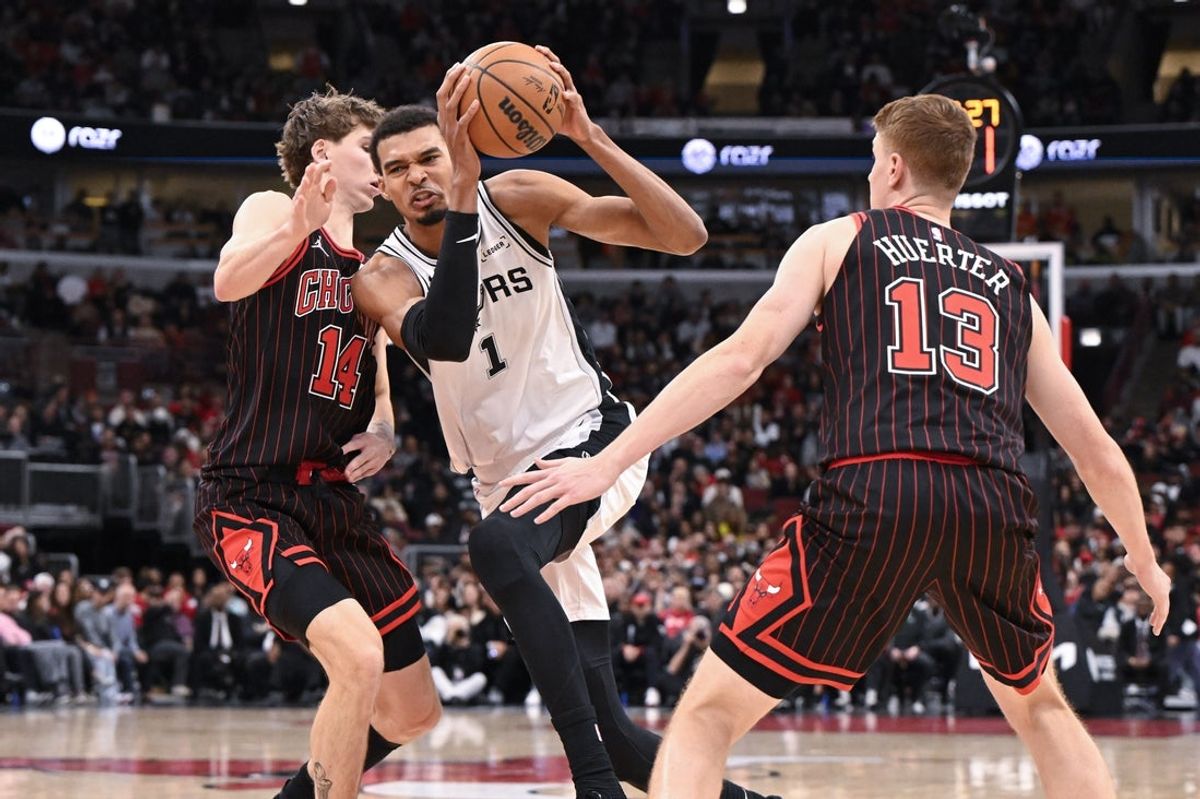 Nov 10, 2025; Chicago, Illinois, USA;  San Antonio Spurs forward Victor Wembanyama (1) drives to the basket against Chicago Bulls forward Matas Buzelis (14) and  guard Kevin Huerter (13) during the second half at the United Center. Mandatory Credit: Matt Marton-Imagn Images