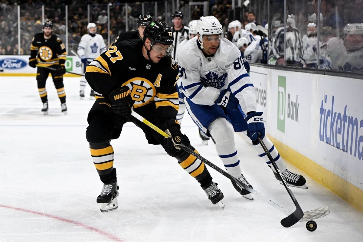 Nov 11, 2025; Boston, Massachusetts, USA; Toronto Maple Leafs center Dakota Joshua (81) controls the puck against Boston Bruins defenseman Hampus Lindholm (27) during the second period at the TD Garden. Mandatory Credit: Brian Fluharty-Imagn Images