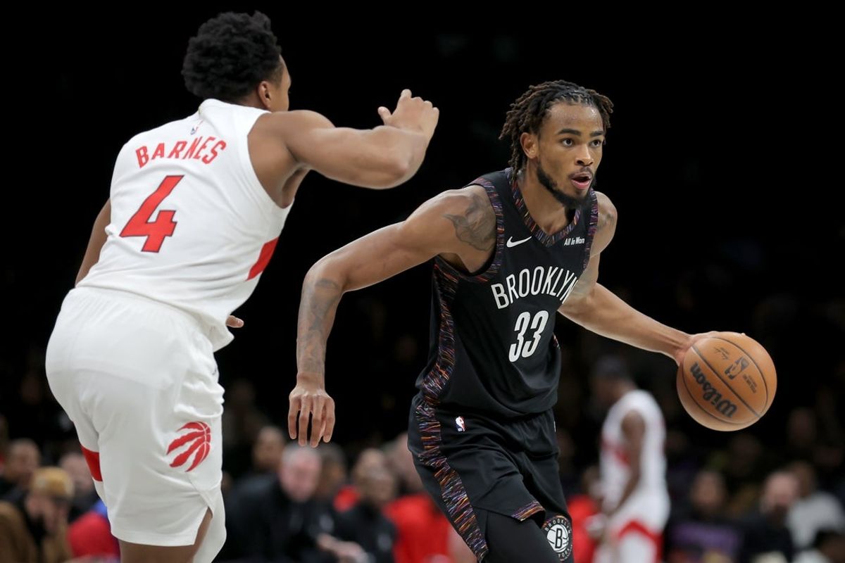 Nov 11, 2025; Brooklyn, New York, USA; Brooklyn Nets center Nic Claxton (33) controls the ball against Toronto Raptors forward Scottie Barnes (4) during the fourth quarter at Barclays Center. Mandatory Credit: Brad Penner-Imagn Images