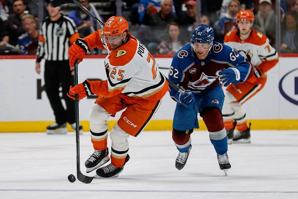 Nov 11, 2025; Denver, Colorado, USA; Anaheim Ducks center Ryan Poehling (25) controls the puck ahead of Colorado Avalanche left wing Artturi Lehkonen (62) in the third period at Ball Arena. Mandatory Credit: Isaiah J. Downing-Imagn Images