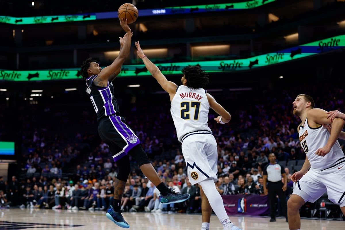 Nov 11, 2025; Sacramento, California, USA; Sacramento Kings guard Malik Monk (0) shoots the ball against Denver Nuggets guard Jamal Murray (27) during the fourth quarter at Golden 1 Center. Mandatory Credit: Sergio Estrada-Imagn Images