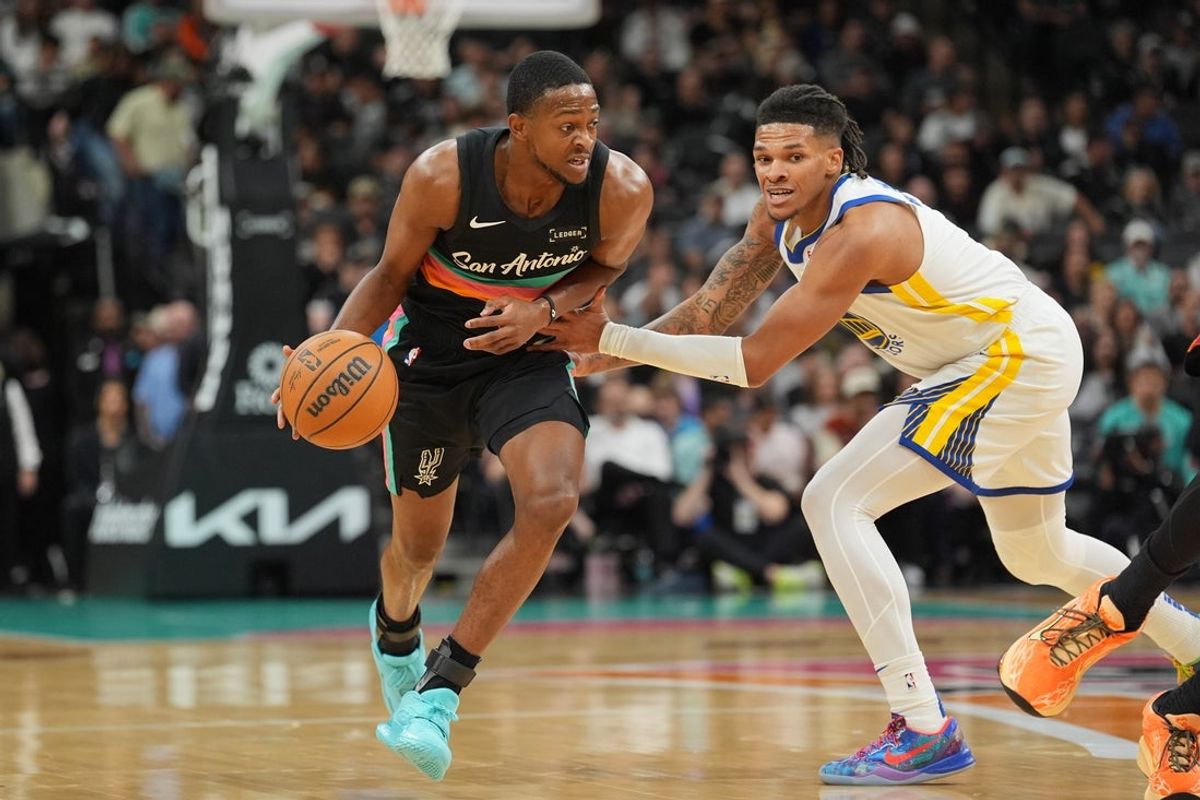 Nov 12, 2025; San Antonio, Texas, USA;  San Antonio Spurs guard De'Aaron Fox (4) dribbles against Golden State Warriors guard Will Richard (3) in the first half at Frost Bank Center. Mandatory Credit: Daniel Dunn-Imagn Images