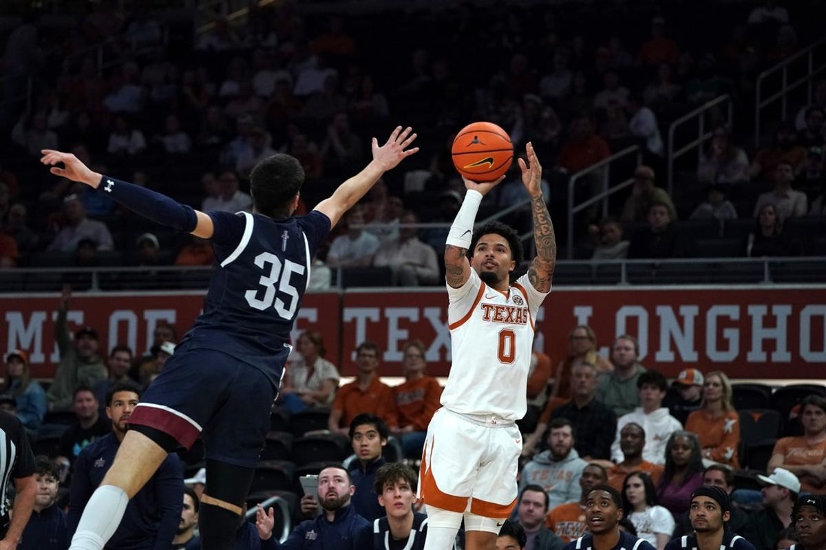 Nov 12, 2025; Austin, Texas, USA; Texas Longhorns guard Jordan Pope (0) makes a three point basket against Fairleigh Dickinson guard David Jevtic (35) during the first half at Moody Center. Mandatory Credit: Dustin Safranek-Imagn Images