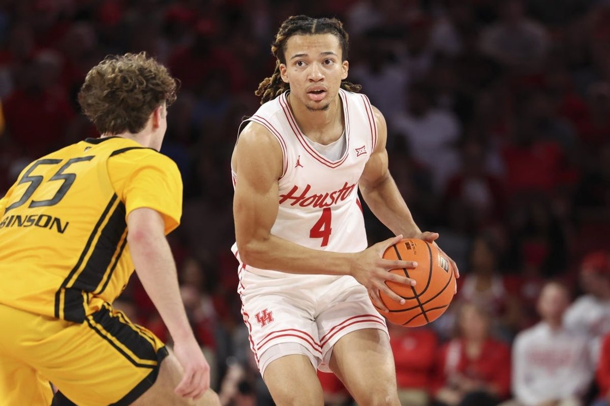 Nov 12, 2025; Houston, Texas, USA; Houston Cougars guard Kingston Flemings (4) controls the ball as Oakland Golden Grizzlies guard Brody Robinson (55) defends during the first half at Fertitta Center. Mandatory Credit: Troy Taormina-Imagn Images
