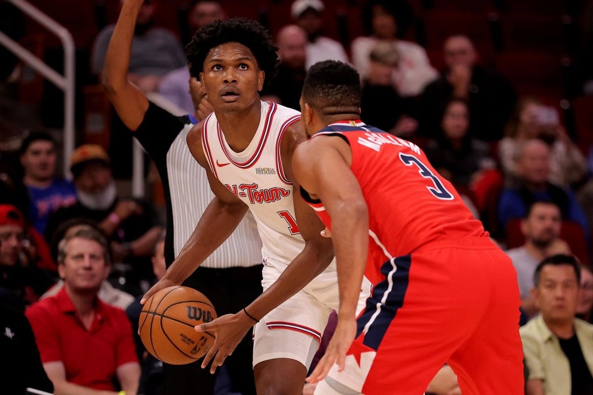 Nov 12, 2025; Houston, Texas, USA; Houston Rockets guard Amen Thompson (1) handles the ball against Washington Wizards guard CJ McCollum (3) during the second quarter at Toyota Center. Mandatory Credit: Erik Williams-Imagn Images