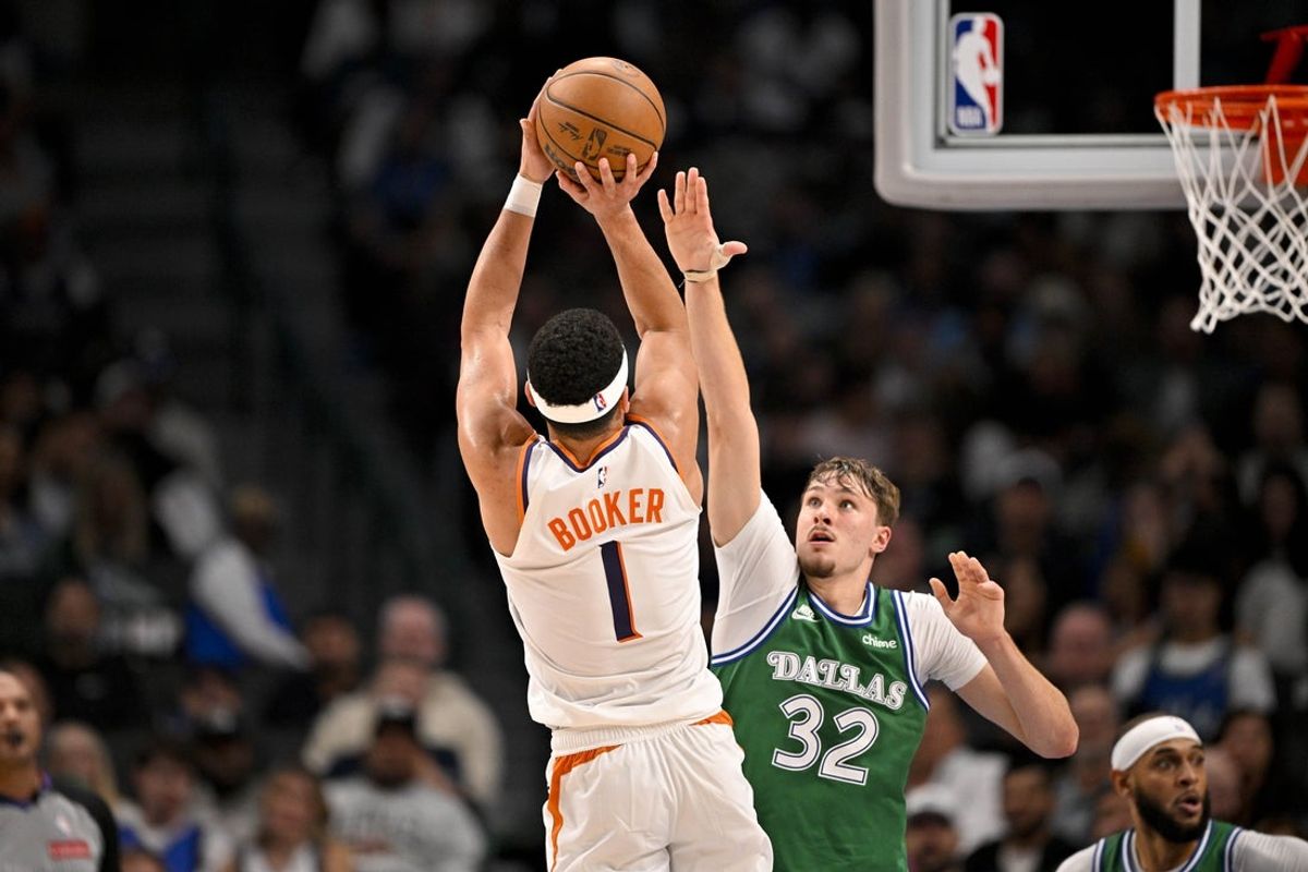 Nov 12, 2025; Dallas, Texas, USA; Phoenix Suns guard Devin Booker (1) shoots the ball over Dallas Mavericks forward Cooper Flagg (32) during the second quarter at the American Airlines Center. Mandatory Credit: Jerome Miron-Imagn Images