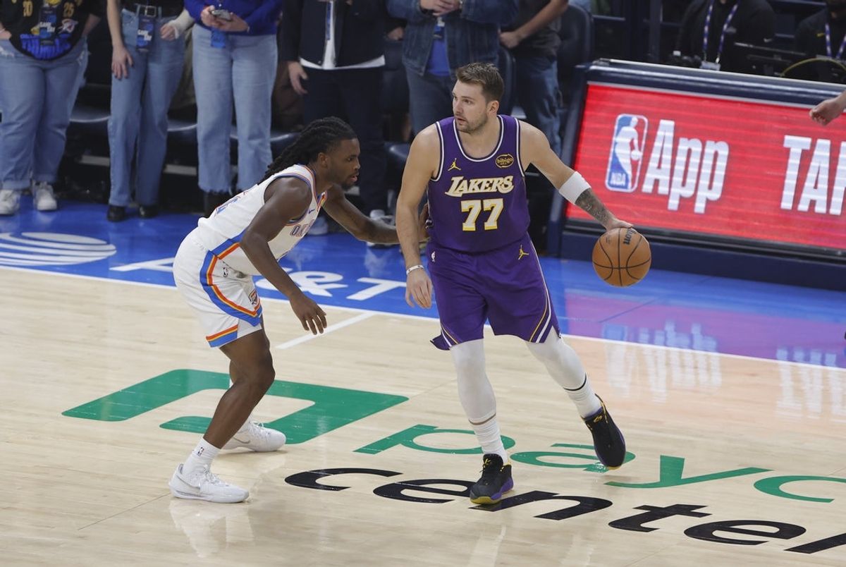 Nov 12, 2025; Oklahoma City, Oklahoma, USA; Los Angeles Lakers guard Luka Doncic (77) moves the ball as Oklahoma City Thunder guard Isaiah Joe (11) defends during the first quarter at Paycom Center. Mandatory Credit: Alonzo Adams-Imagn Images