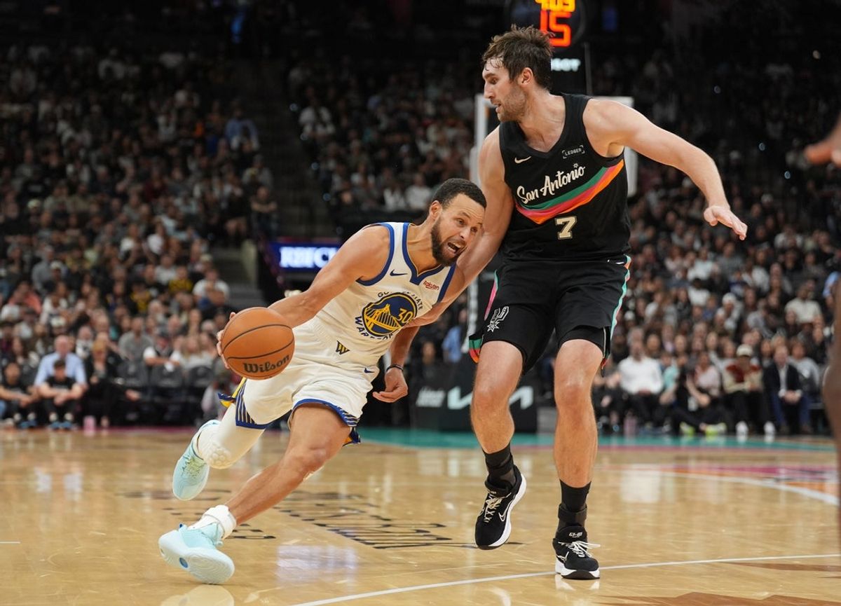 Nov 12, 2025; San Antonio, Texas, USA;  Golden State Warriors guard Stephen Curry (30) drives past San Antonio Spurs center Luke Kornet (7) in the second half at Frost Bank Center. Mandatory Credit: Daniel Dunn-Imagn Images