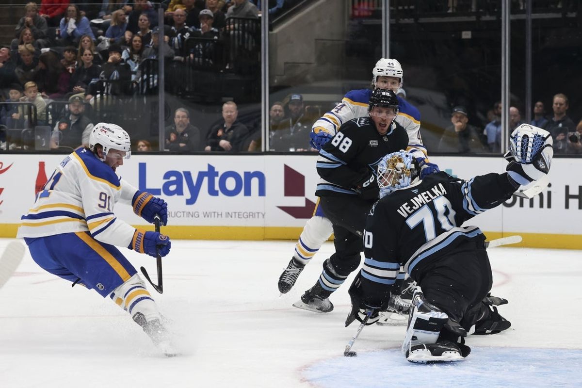 Nov 12, 2025; Salt Lake City, Utah, USA; Utah Mammoth goaltender Karel Vejmelka (70) blocks a shot by Buffalo Sabres right wing Josh Doan (91) during the second period at Delta Center. Mandatory Credit: Rob Gray-Imagn Images