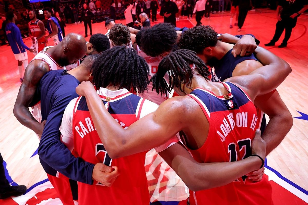Nov 12, 2025; Houston, Texas, USA; Members of the Houston Rockets and Washington Wizards huddle together at midcourt following the game at Toyota Center. Mandatory Credit: Erik Williams-Imagn Images