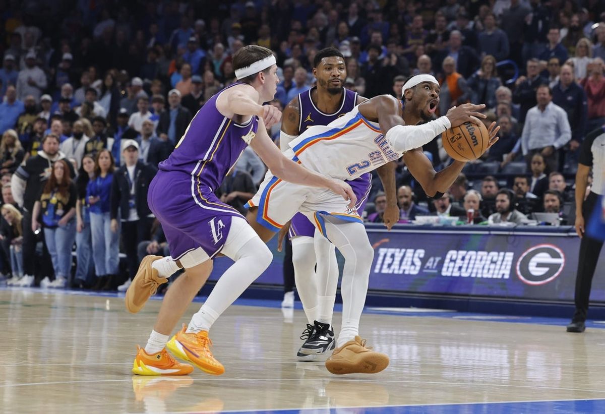 Nov 12, 2025; Oklahoma City, Oklahoma, USA; Oklahoma City Thunder guard Shai Gilgeous-Alexander (2) drives between Los Angeles Lakers guard Austin Reaves (15) and guard Marcus Smart (36) during the second quarter at Paycom Center. Mandatory Credit: Alonzo Adams-Imagn Images