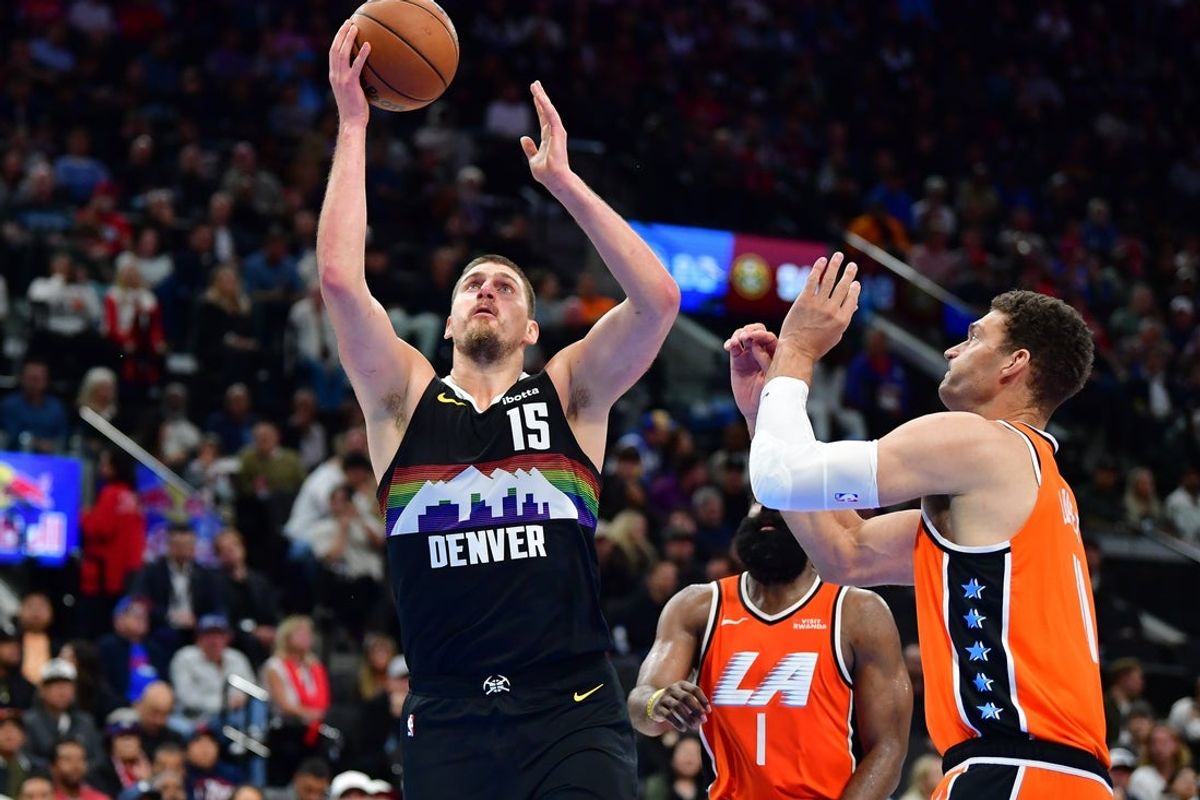 Nov 12, 2025; Inglewood, California, USA; Denver Nuggets center Nikola Jokic (15) moves to the basket against Los Angeles Clippers center Brook Lopez (11) during the second half at Intuit Dome. Mandatory Credit: Gary A. Vasquez-Imagn Images