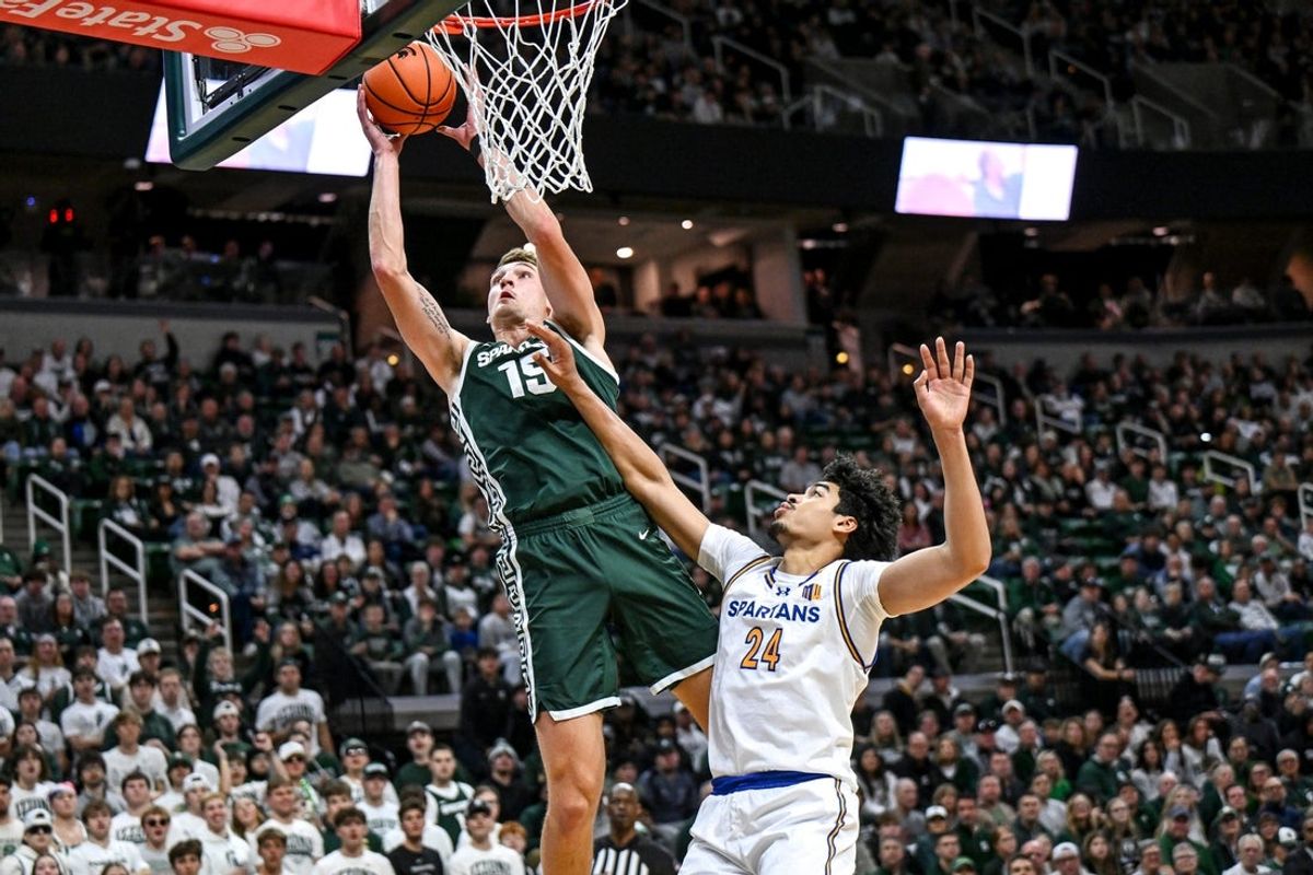 Michigan State's Carson Cooper, left, scores as San Jose State's Douglas Langford defends during the first half on Thursday, Nov. 13, 2025, at the Breslin Center in East Lansing.