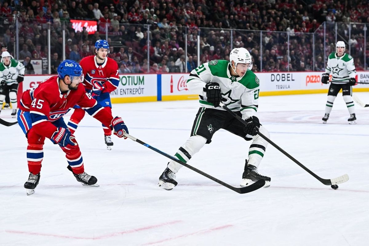 Nov 13, 2025; Montreal, Quebec, CAN; Dallas Stars left wing Jason Robertson (21) plays the puck against Montreal Canadiens defenseman Alexandre Carrier (45) during the first period at Bell Centre. Mandatory Credit: David Kirouac-Imagn Images