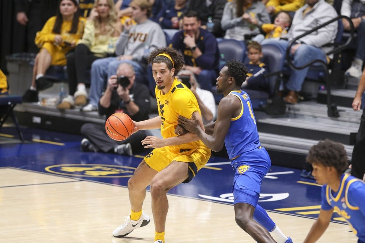 Nov 13, 2025; Morgantown, West Virginia, USA; West Virginia Mountaineers center Harlan Obioha (55) dribbles against Pittsburgh Panthers forward Papa Amadou Kante (4) during the second half at WVU Coliseum. Mandatory Credit: Ben Queen-Imagn Images