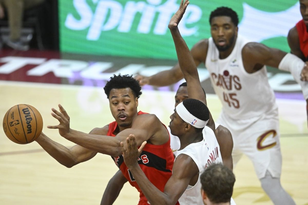 Nov 13, 2025; Cleveland, Ohio, USA; Toronto Raptors forward Scottie Barnes (4) looks to pass beside Cleveland Cavaliers forward Nae'Qwan Tomlin (35) in the fourth quarter at Rocket Arena. Mandatory Credit: David Richard-Imagn Images