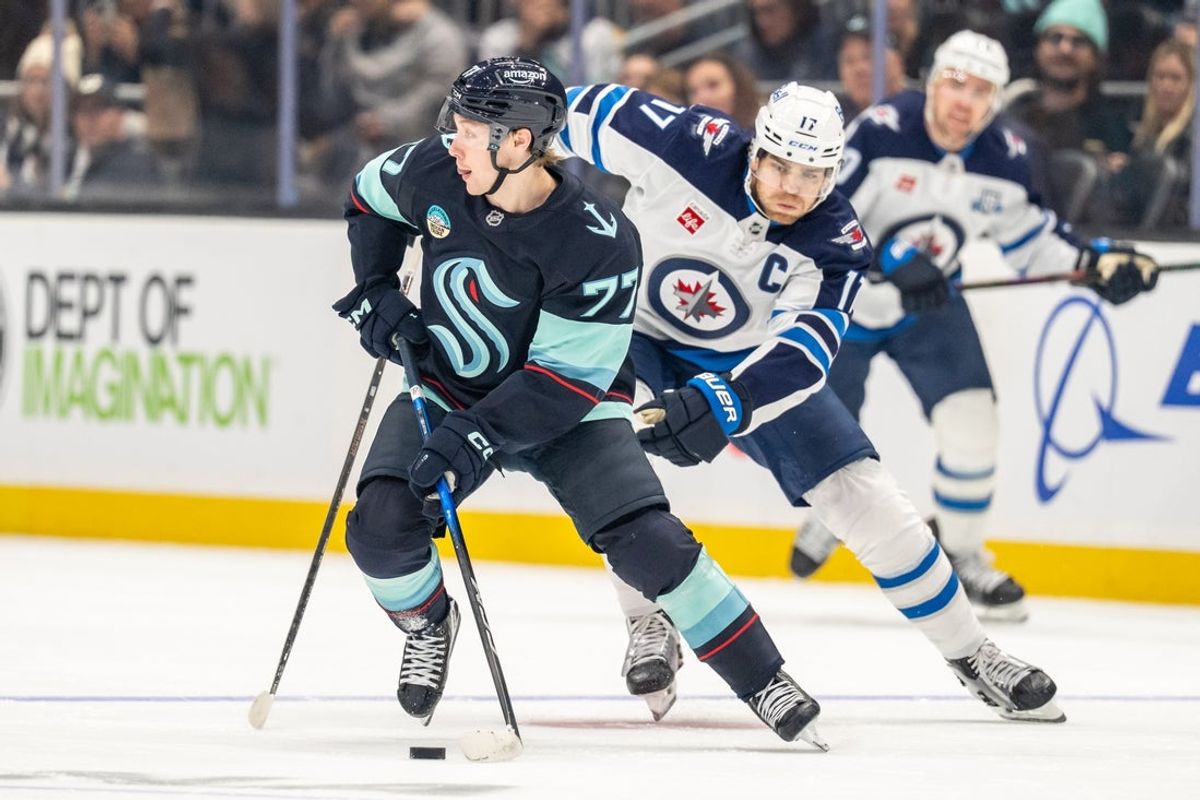 Nov 13, 2025; Seattle, Washington, USA; Seattle Kraken forward Berkly Catton (77) skates against Winnipeg Jets forward Adam Lowry (17) during the first period at Climate Pledge Arena. Mandatory Credit: Stephen Brashear-Imagn Images
