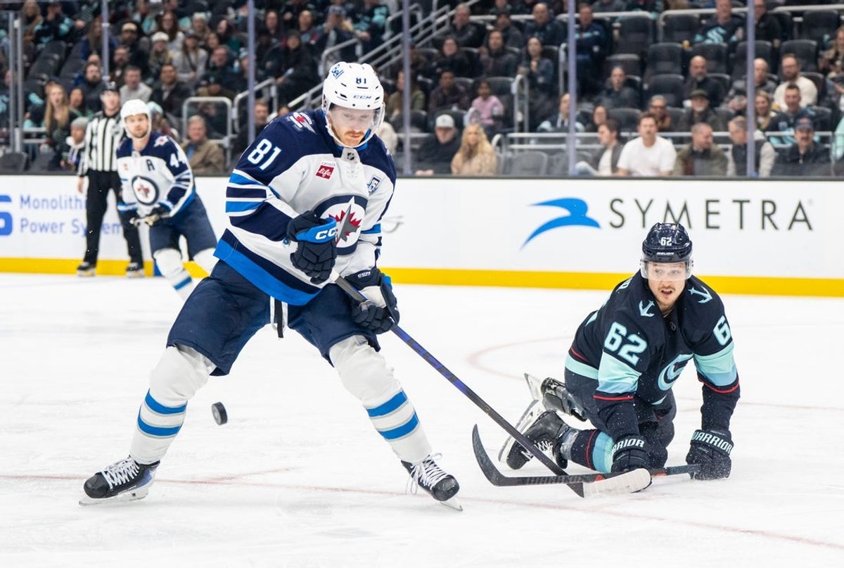 Nov 13, 2025; Seattle, Washington, USA; Winnipeg Jets forward Kyle Connor (81) and Seattle Kraken defenseman Brandon Montour (62) battle for the puck during the third period at Climate Pledge Arena. Mandatory Credit: Stephen Brashear-Imagn Images