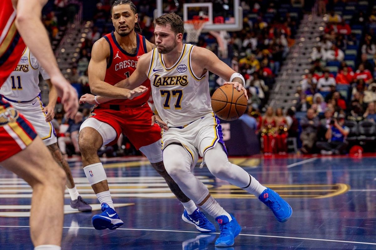 Nov 14, 2025; New Orleans, Louisiana, USA;  Los Angeles Lakers forward/guard Luka Doncic (77) dribbles agaisnt New Orleans Pelicans guard/forward Micah Peavy (14) during the first half at Smoothie King Center. Mandatory Credit: Stephen Lew-Imagn Images