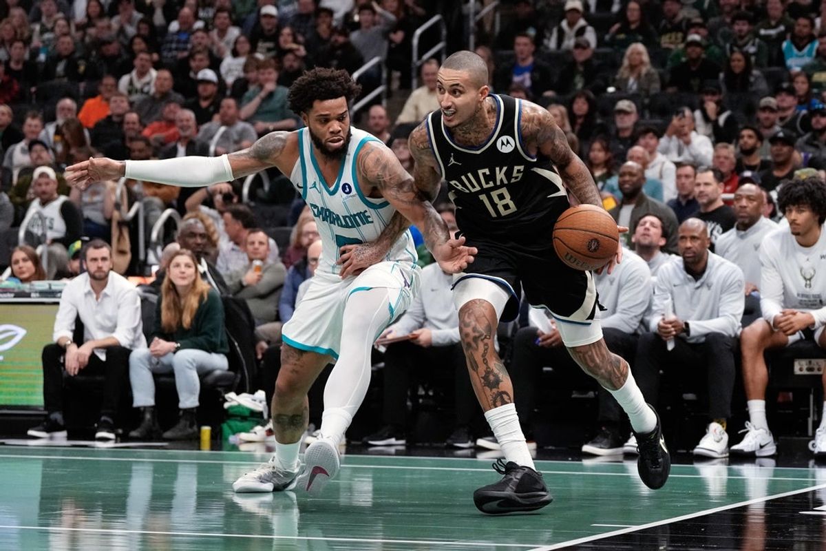 Nov 14, 2025; Milwaukee, Wisconsin, USA;  Milwaukee Bucks forward Kyle Kuzma (18) drives towards the basket against Charlotte Hornets forward Miles Bridges (0) during the third quarter at Fiserv Forum. Mandatory Credit: Jeff Hanisch-Imagn Images