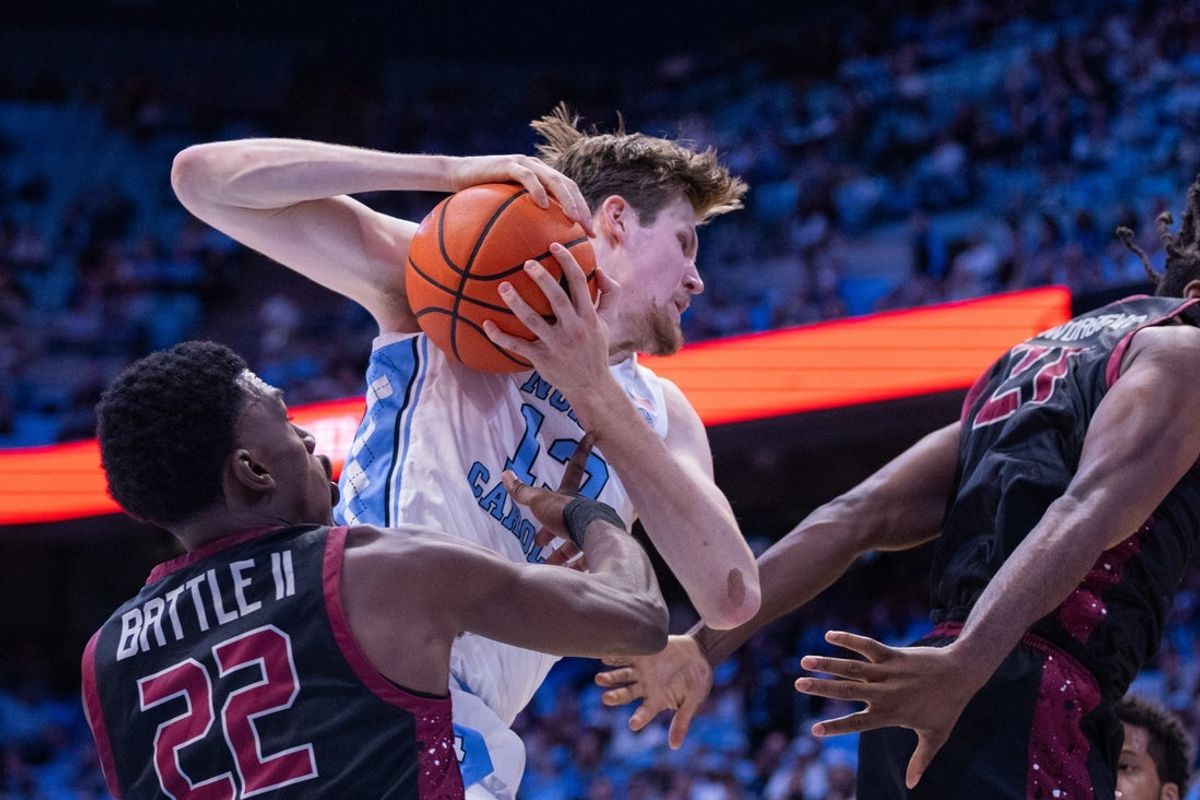 Nov 14, 2025; Chapel Hill, North Carolina, USA; North Carolina Tar Heels center Henri Veesaar (13) pulls in a rebound against North Carolina Central Eagles forward Ramondo Battle II (22) in the first half at Dean E. Smith Center. Mandatory Credit: Scott Kinser-Imagn Images