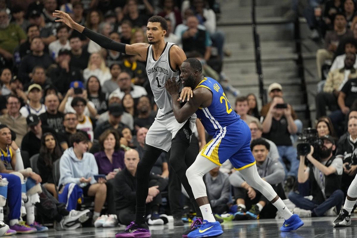 Nov 14, 2025; San Antonio, Texas, USA; San Antonio Spurs forward Victor Wembanyama (1) posts up on Golden State Warriors forward Draymond Green (23) during the first half at Frost Bank Center. Mandatory Credit: Scott Wachter-Imagn Images