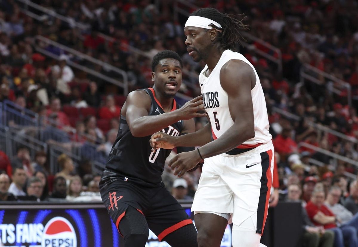 Nov 14, 2025; Houston, Texas, USA;  Houston Rockets guard Aaron Holiday (0) defends against Portland Trail Blazers guard Jrue Holiday (5) during the third quarter at Toyota Center. Mandatory Credit: Troy Taormina-Imagn Images